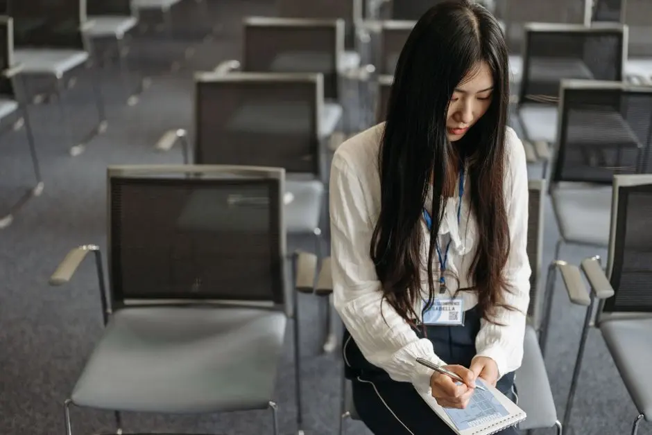 Seorang profesional muda sedang mencatat materi pelatihan daring